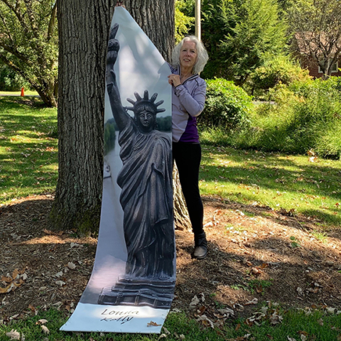 Lonna Kelly holding up her Statue of Liberty Banner