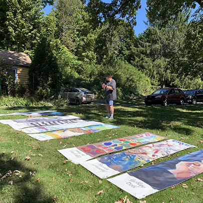 Bill Prickett standing and viewing banners laid out flat on lawn