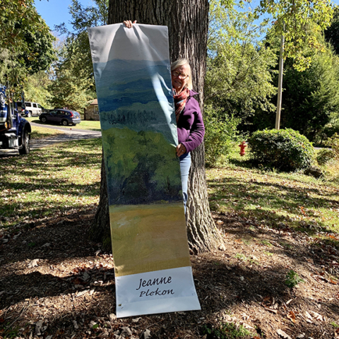 Jeanne Plekon holding up her landscape image on banner