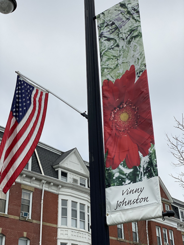 Vinny Johnston Banner red flower abstract background hanging with sky and brick building in backgrouns