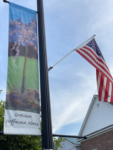 Gretchen Hoffman Abene Banner of spring blooming tree against village building and sky