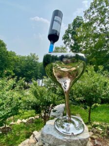 A wind-powered kinetic sculpture with wine glass and bottle shape.