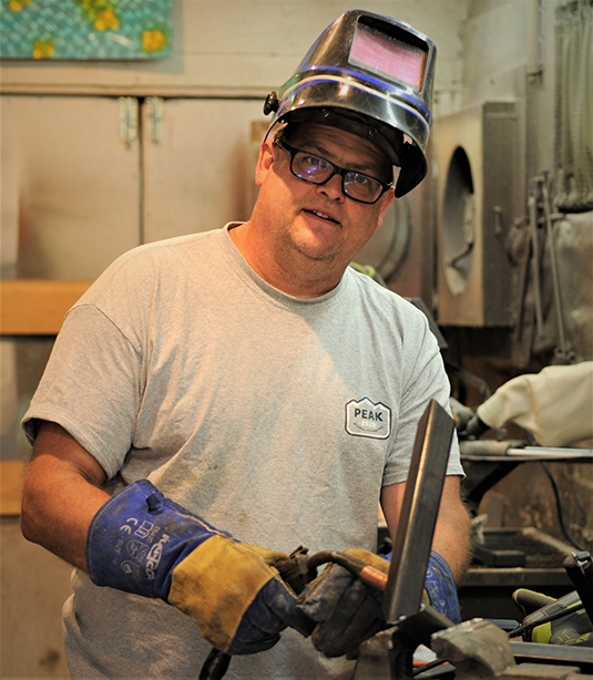 Brian Wohrman in protective gear Creating sculpture