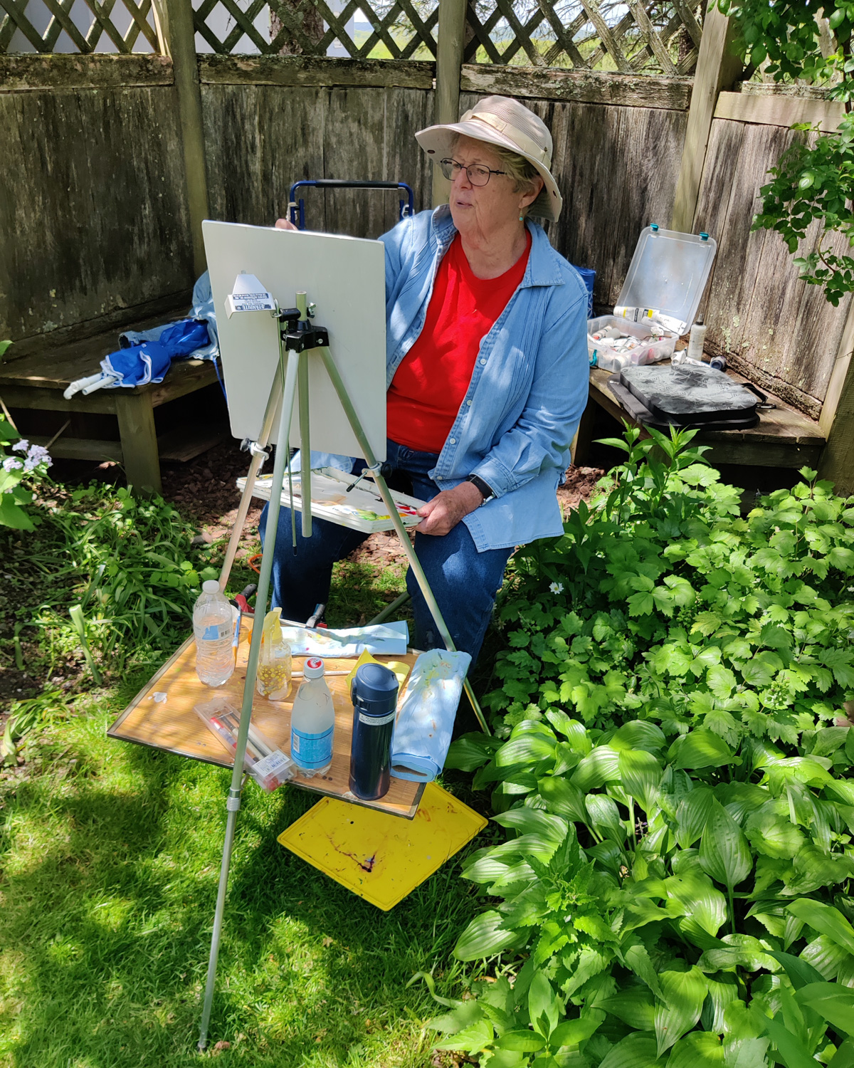 artist painting ourside at her easel on a summer day