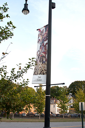 Pat Lane's multi color banner hung from street lamp pole