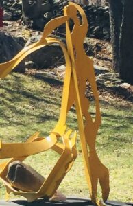 Bright yellow metal figures dancing in an imaginary garden