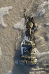 statue of liberty submerged on an ocean beach