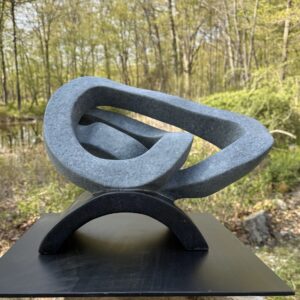 Black soapstone intricately carved sculpture with integrated base