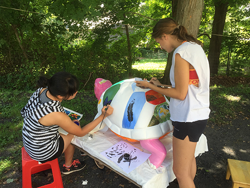 Two Pawling High School students working on turtle in yard