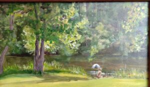 Bright yellow green patches of light against dark trees. Artist painting under umbrella