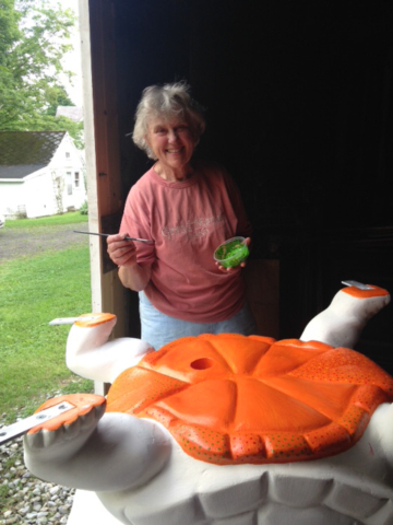 Hennelly in barn painting underside of turtle orange
