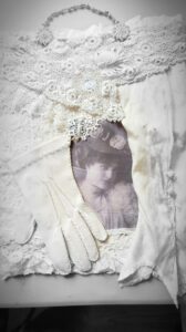 mixed media – image of a Victorian woman surrounded by a vintage glove, sleeve and laces with a vintage necklace hanger.
