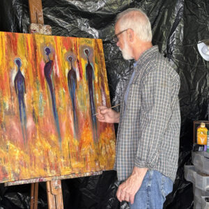 standing man adding finishing touched to vibrantly colored painting